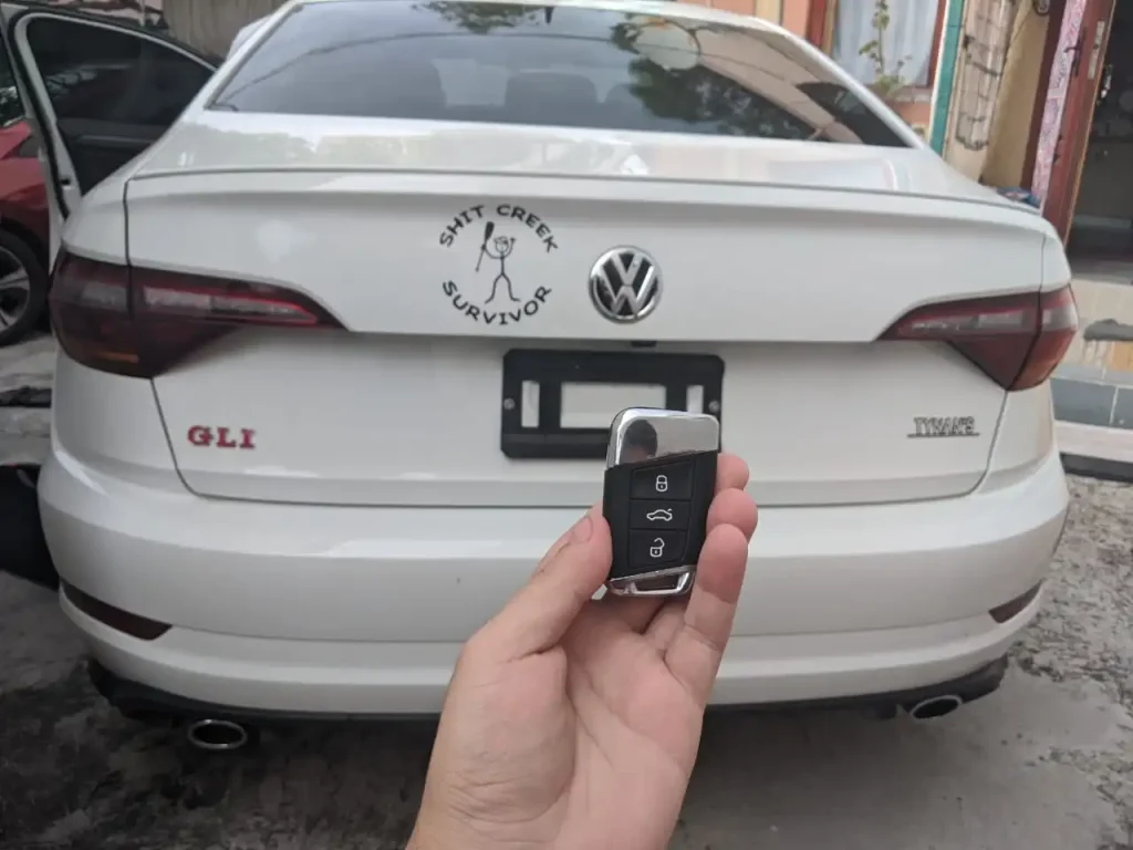 Mobile locksmith technician programming a new smart car key replacement in Miami